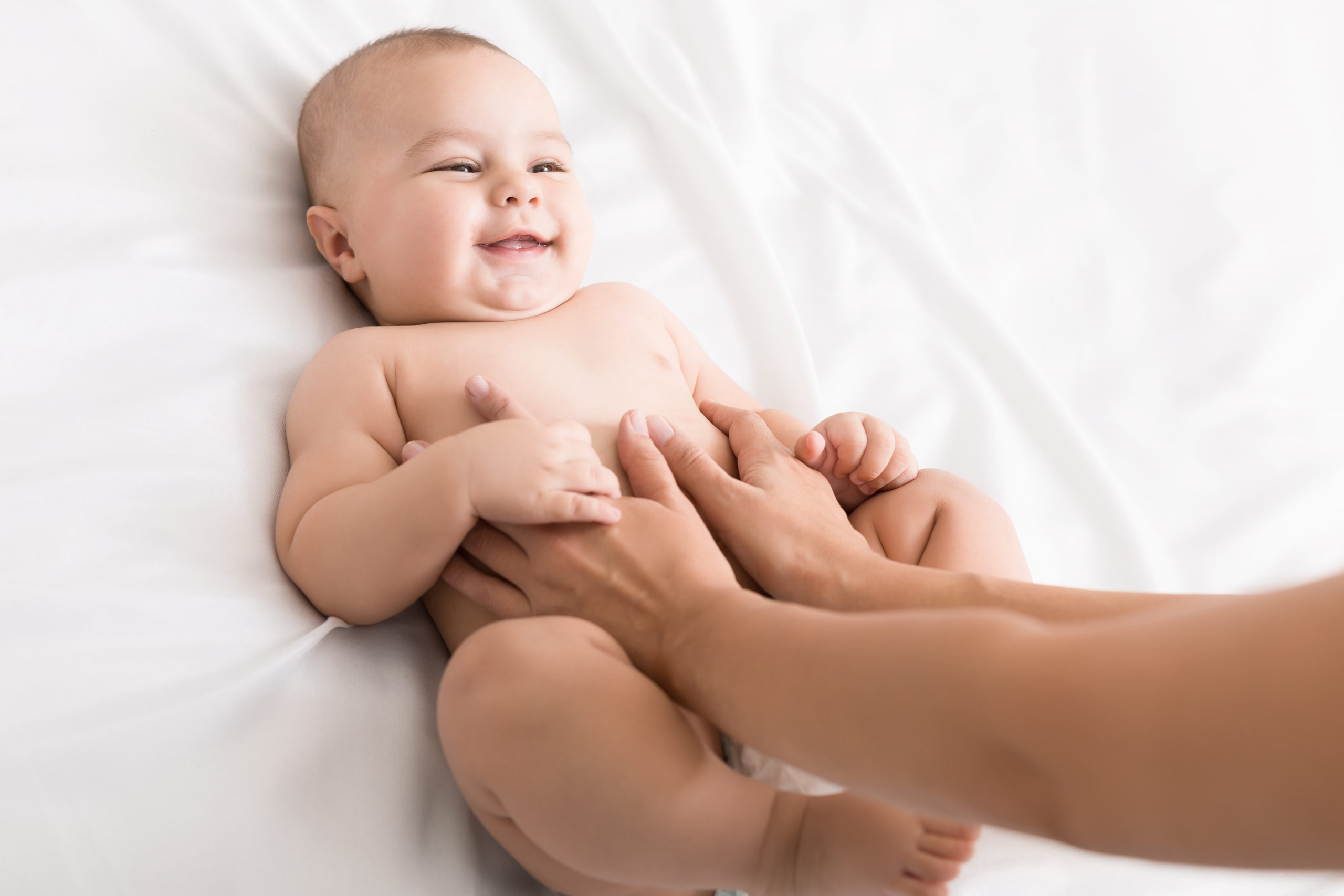 Babymassage Hände auf Babys Bauch